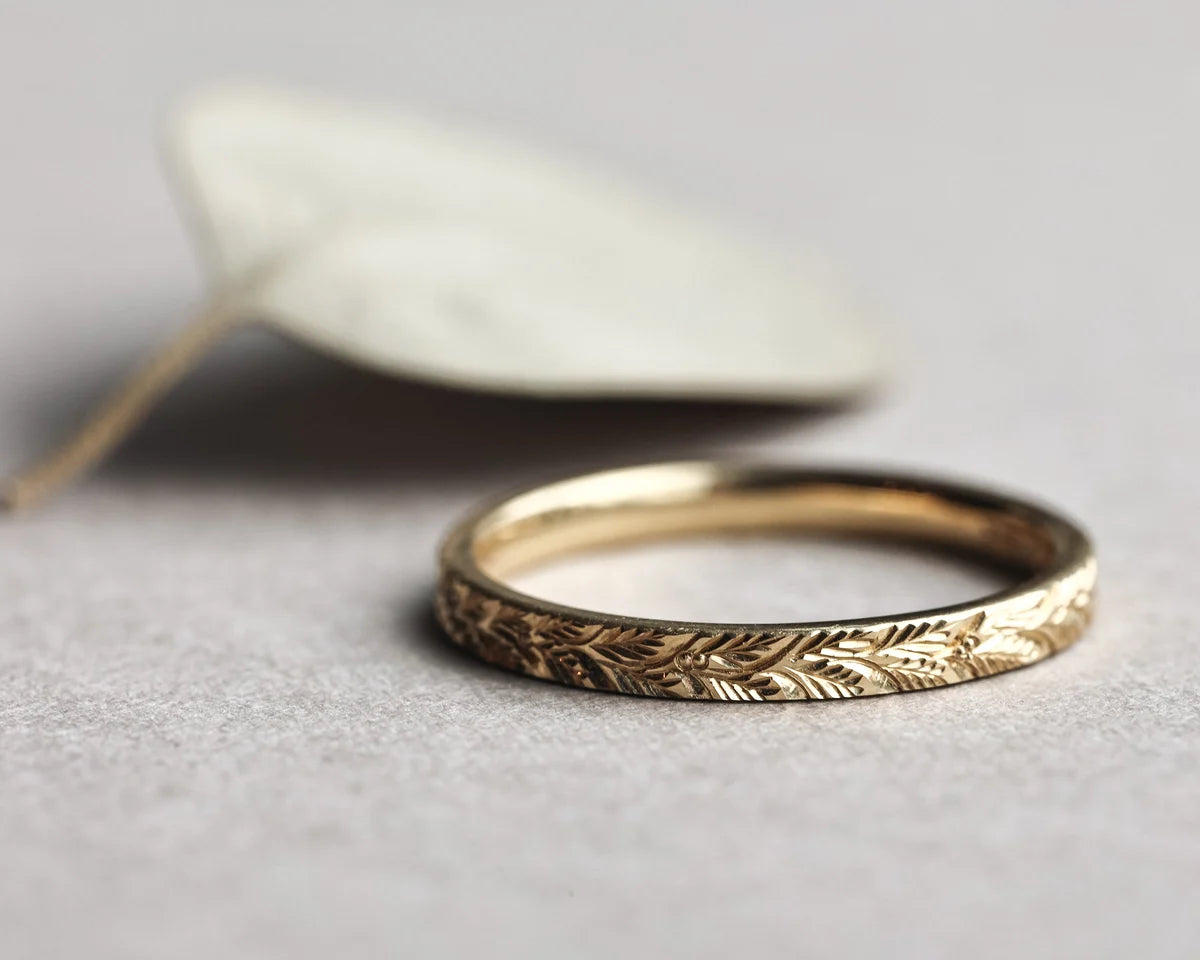 18ct yellow gold laurel leaf wedding ring styled with pale leaf
