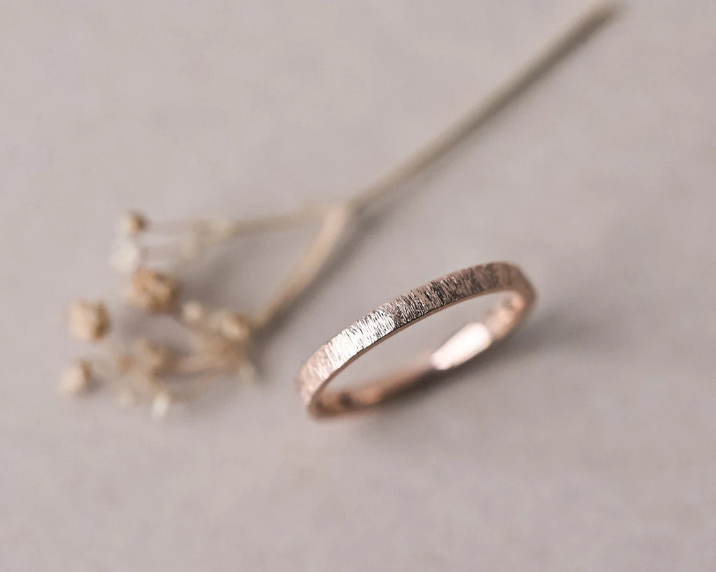 Soft focus view of 18ct rose gold horn texture wedding ring