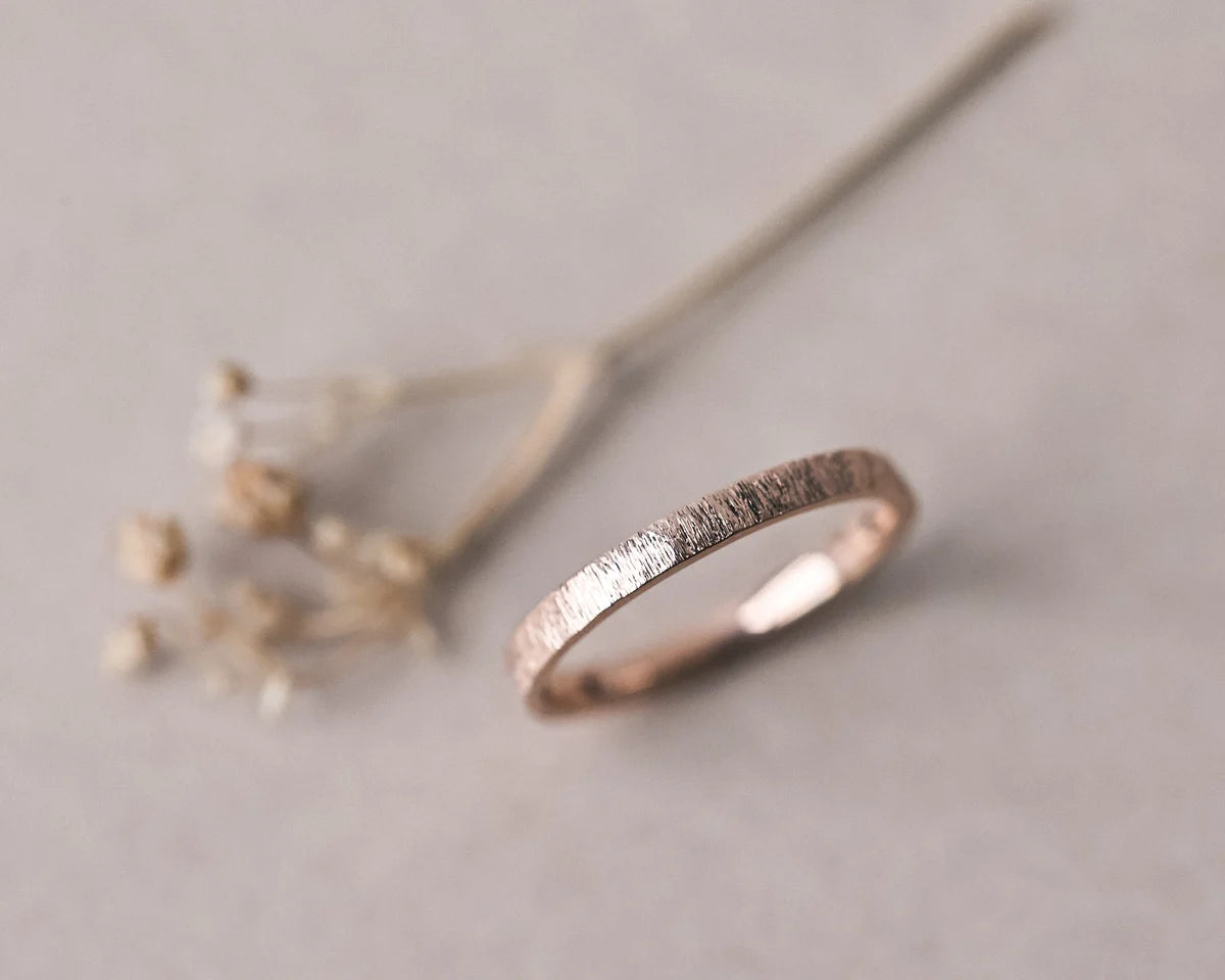 Soft focus view of 18ct rose gold horn texture wedding ring
