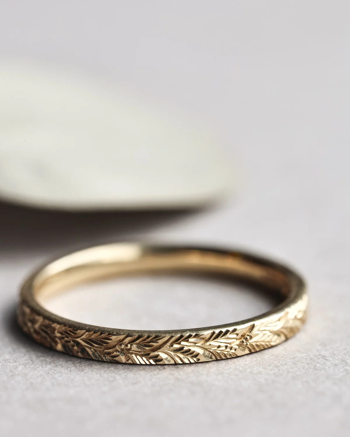 Close-up of handmade 2mm laurel leaf wedding ring in yellow gold