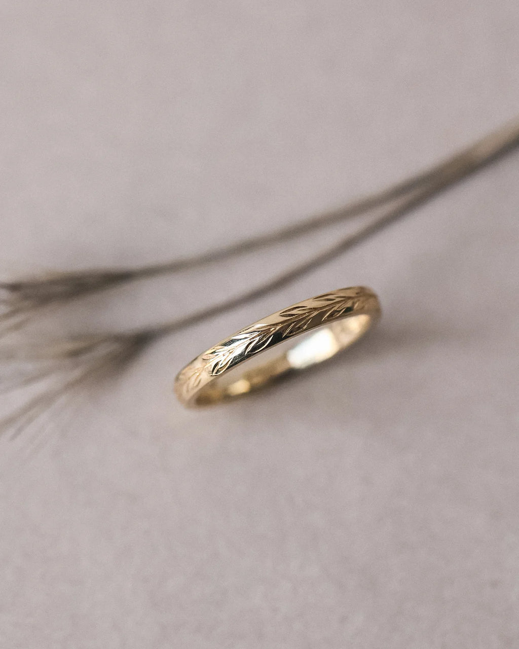 Side view of olive leaf engraved wedding ring in yellow gold