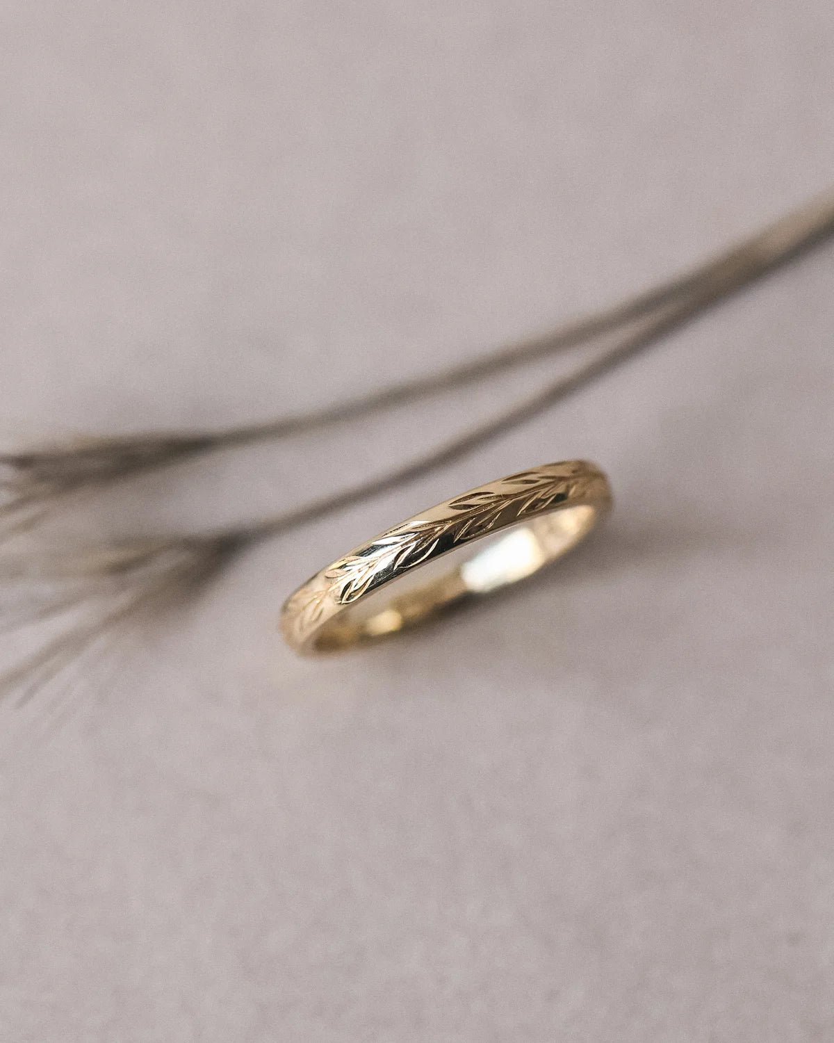 Side view of olive leaf engraved wedding ring in yellow gold