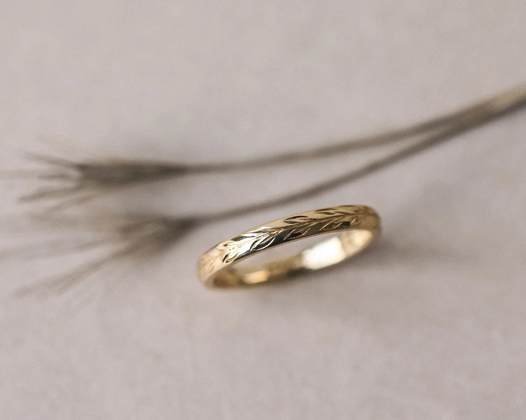 Low side profile of handmade olive leaf engraved ring in yellow gold