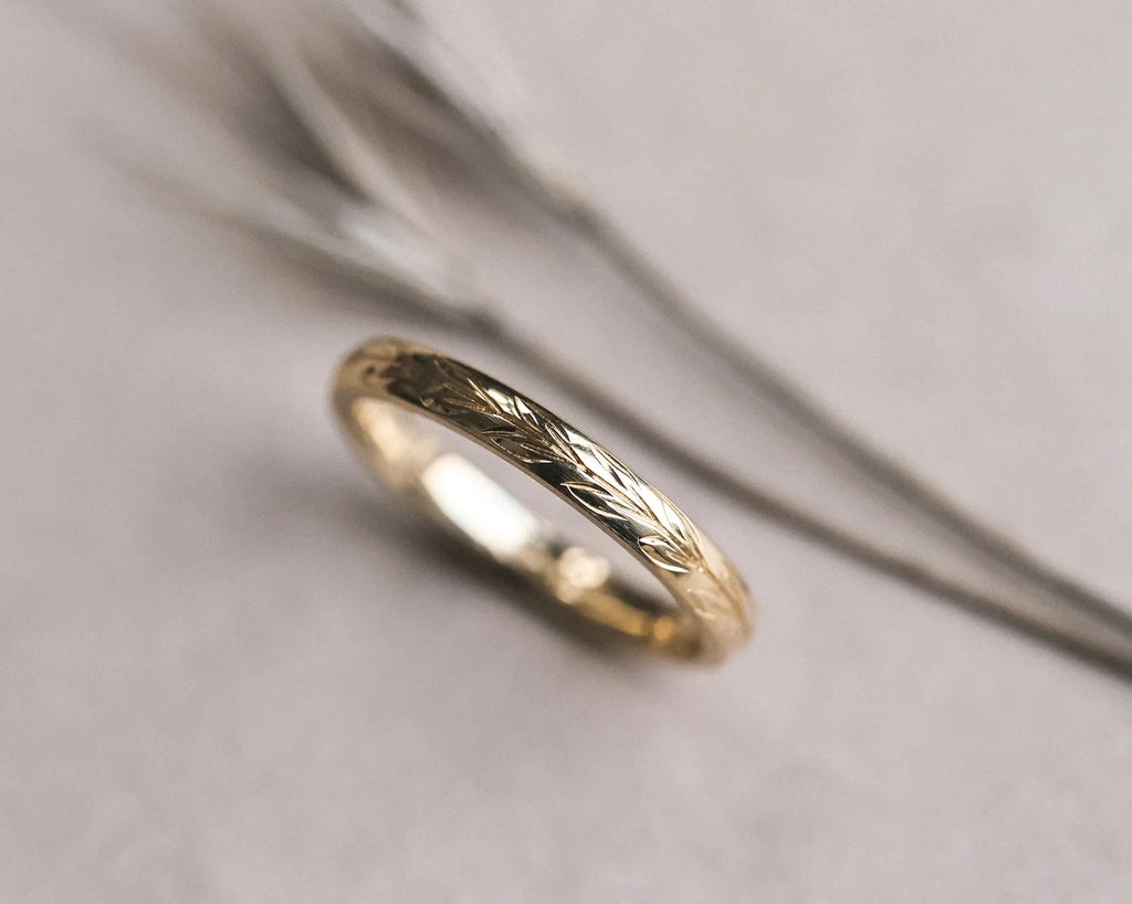 Detailed view of olive leaf engraving on 18ct yellow gold band