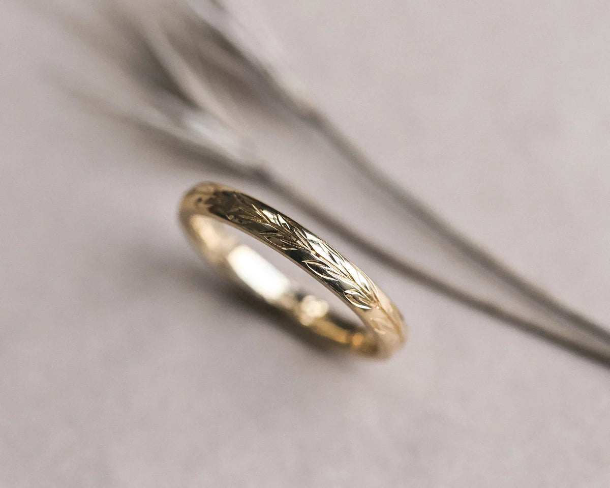 Detailed view of olive leaf engraving on 18ct yellow gold band
