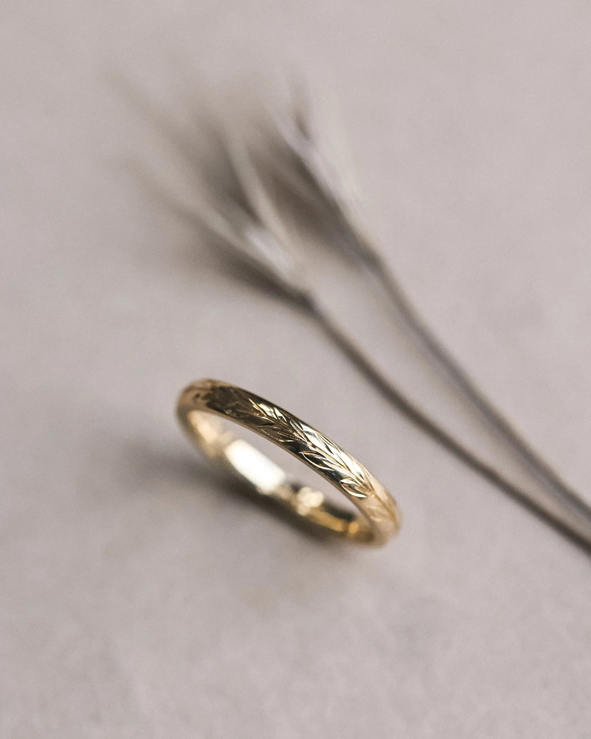 Angled view of 2.5mm yellow gold olive leaf wedding band