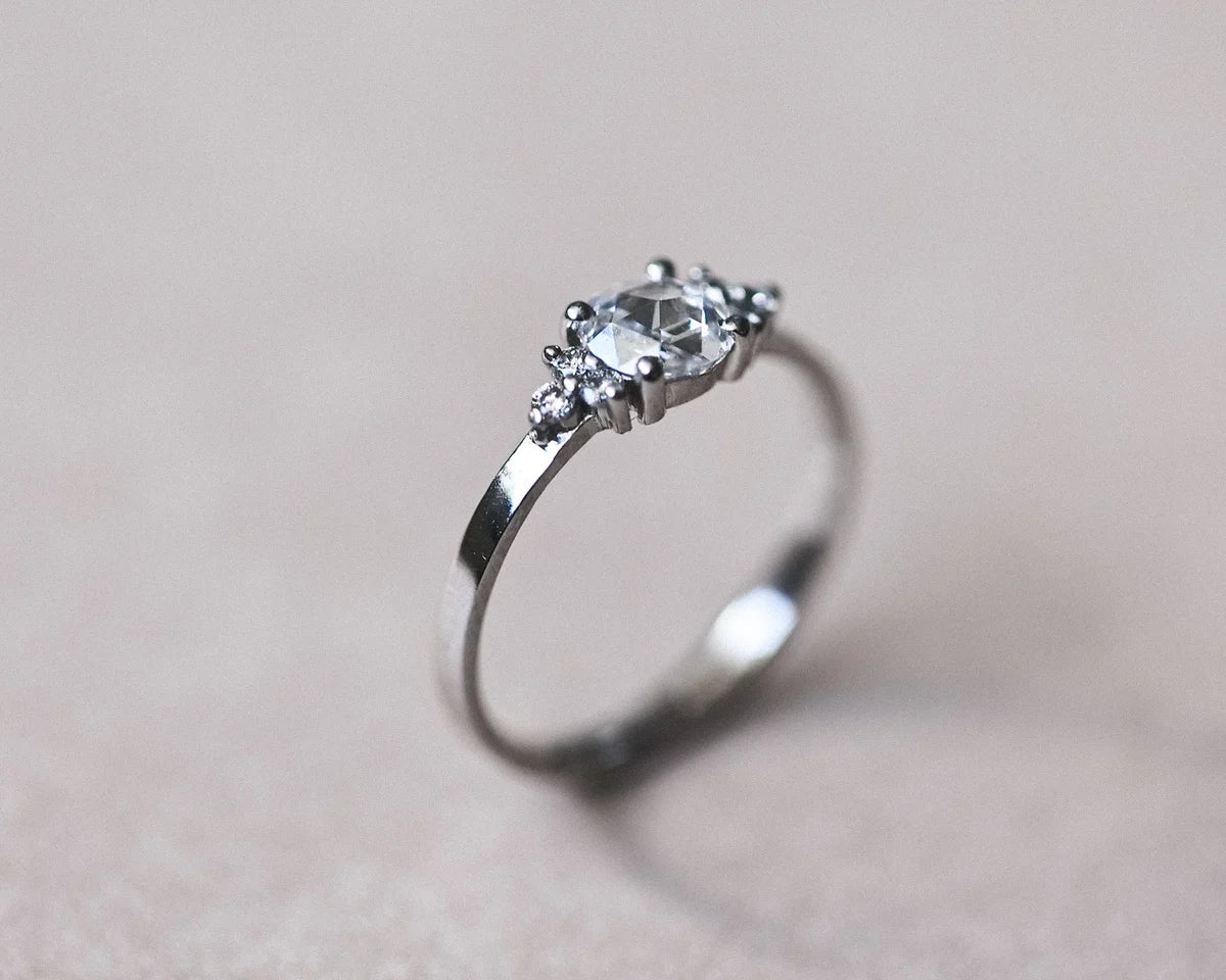 Angled view of platinum rose-cut diamond ring with side stones