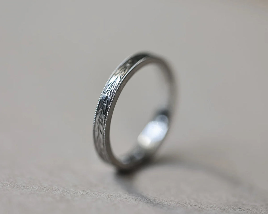 Vertical view of platinum olive leaf and milled edge wedding ring