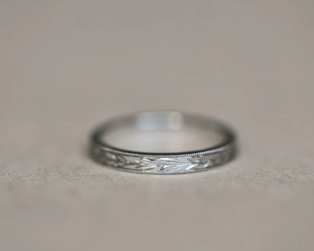 Front view of 2mm platinum wedding band with olive leaf engraving