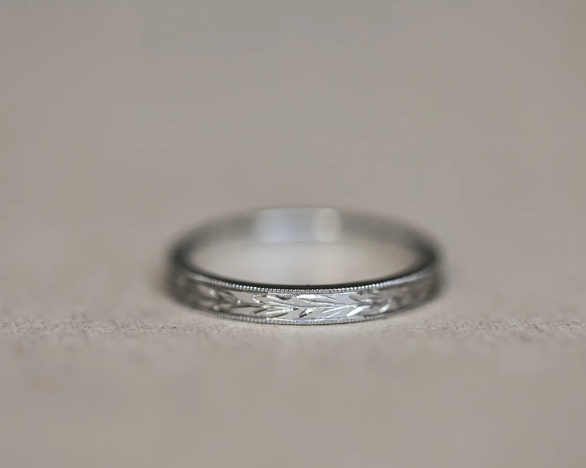Front view of 2mm platinum wedding band with olive leaf engraving