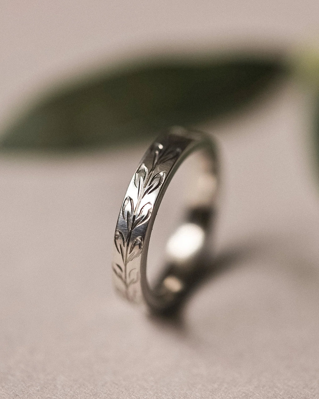 Side view of platinum olive leaf engraved flat court wedding ring