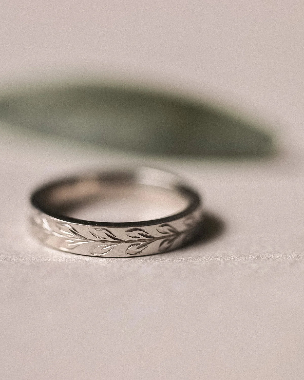 Minimal platinum flat court wedding ring with hand engraved olive leaf motif