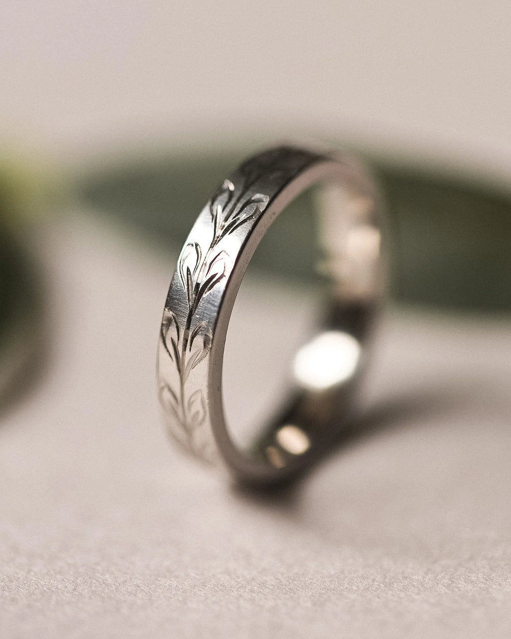 Angled view of 4mm platinum olive leaf engraved wedding band