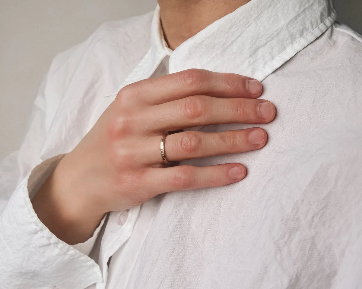Horn texture rose gold wedding ring worn on hand with white shirt
