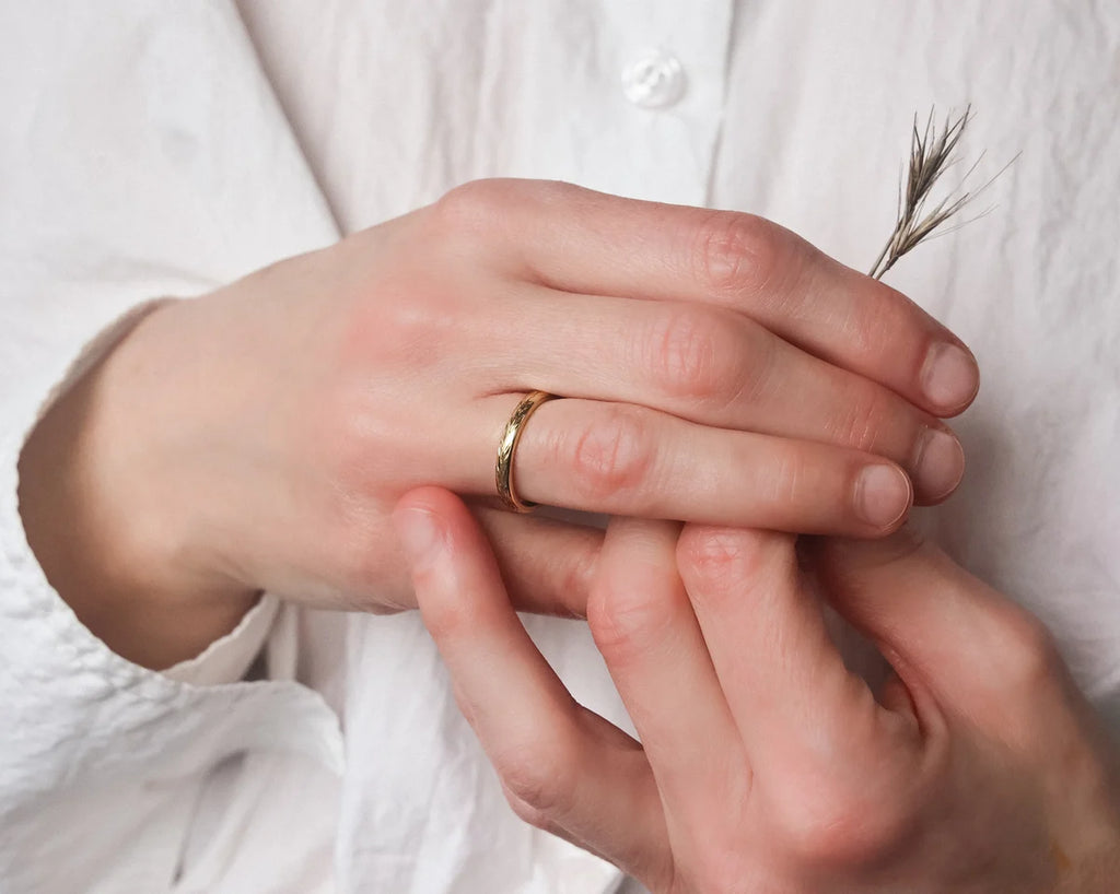 Olive leaf engraved yellow gold wedding ring worn on hand