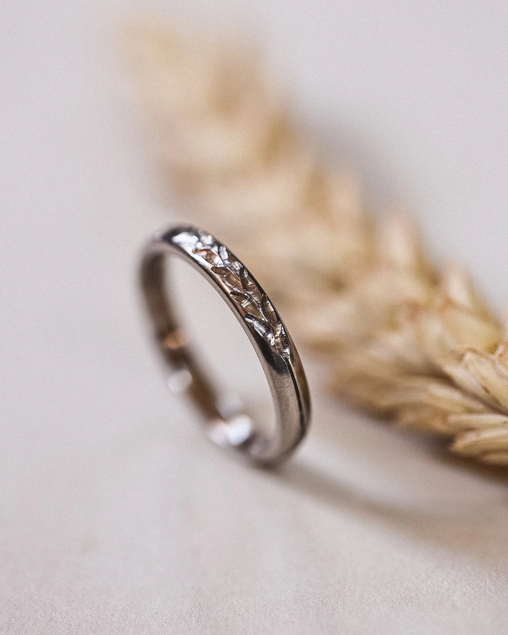 Angled view of hand engraved Barleycorn ring with wheat styling