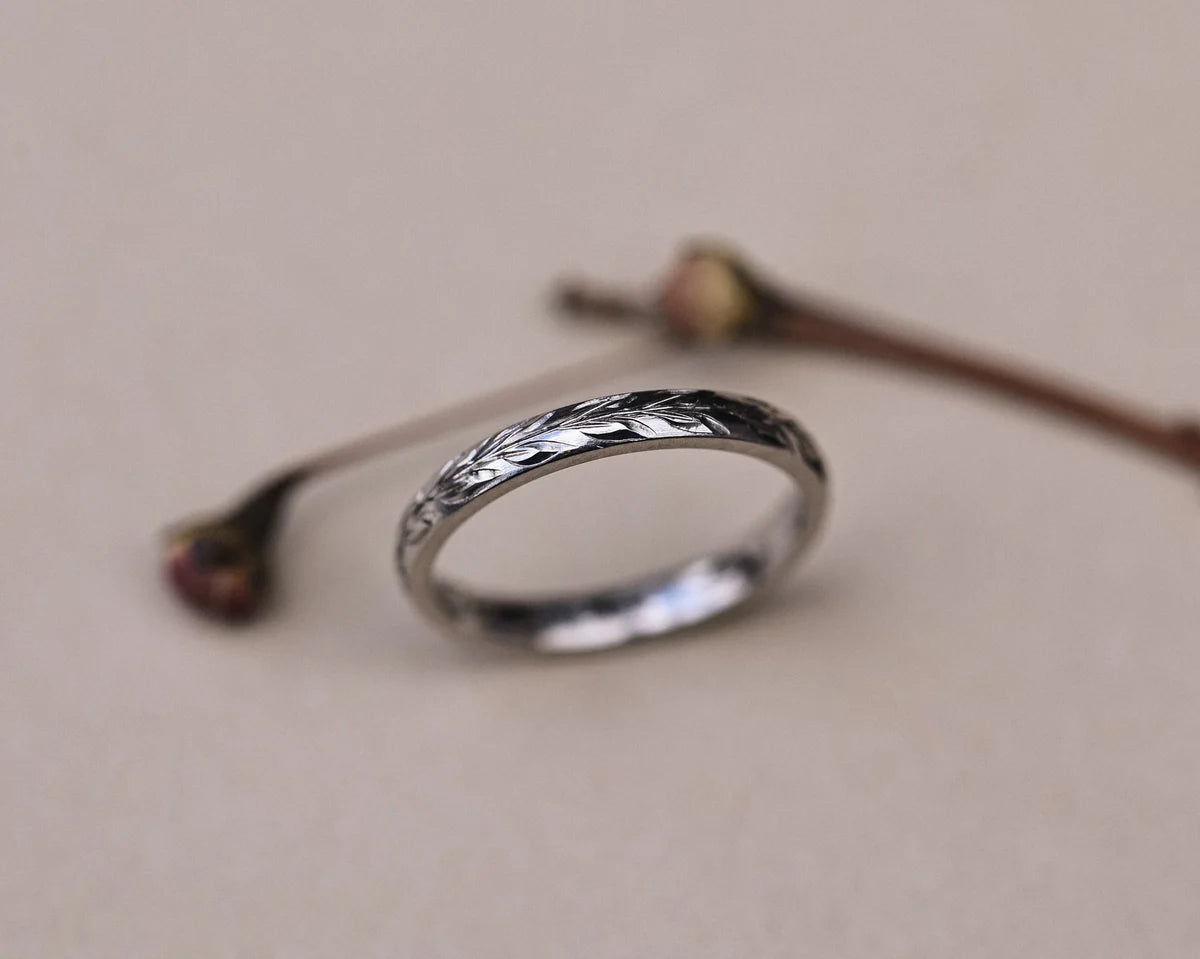 Soft focus view of platinum olive leaf wedding ring