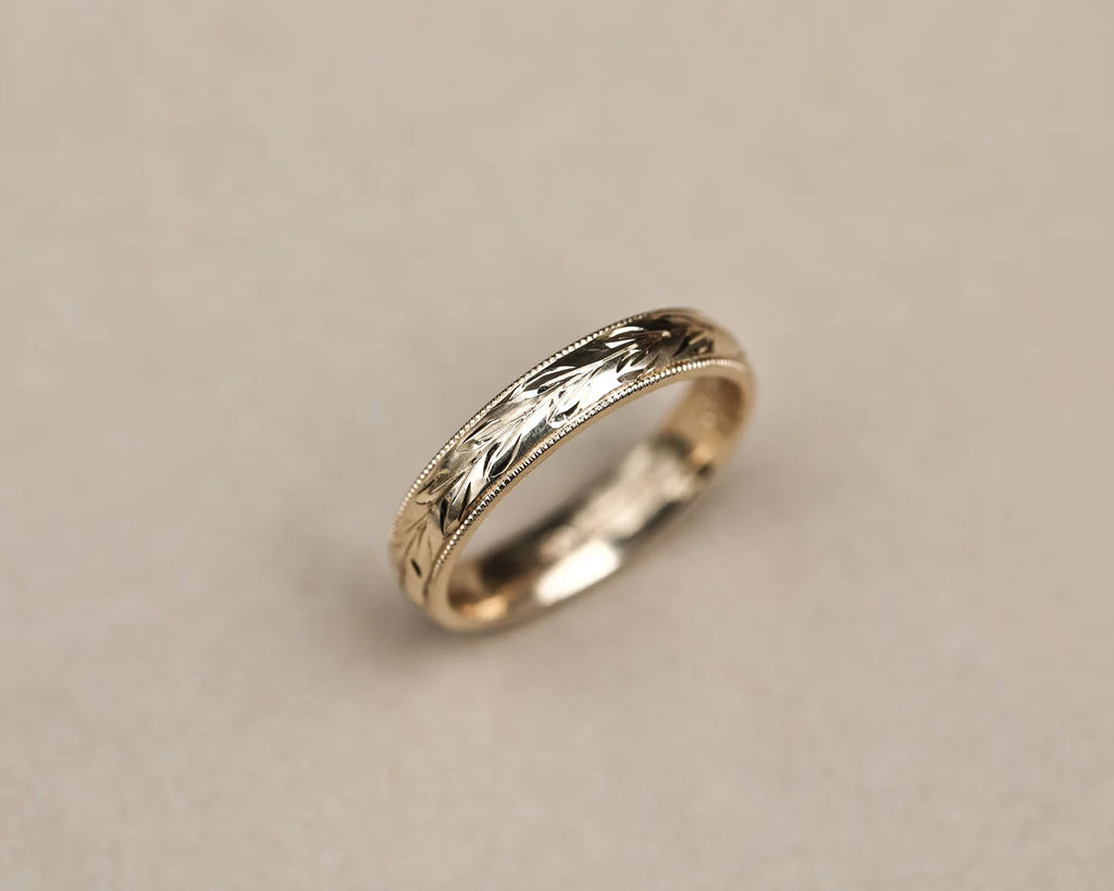 Side view of handmade olive leaf engraved wedding ring in yellow gold