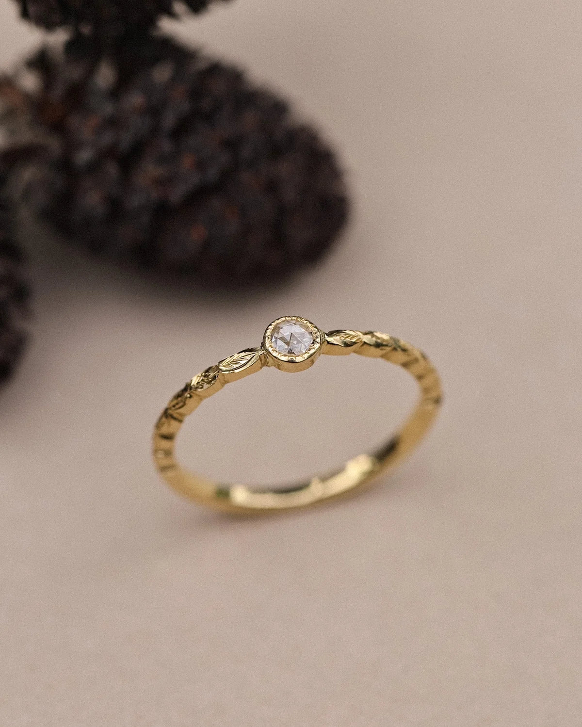 Minimal yellow gold ring with rose-cut diamond and laurel leaf detail