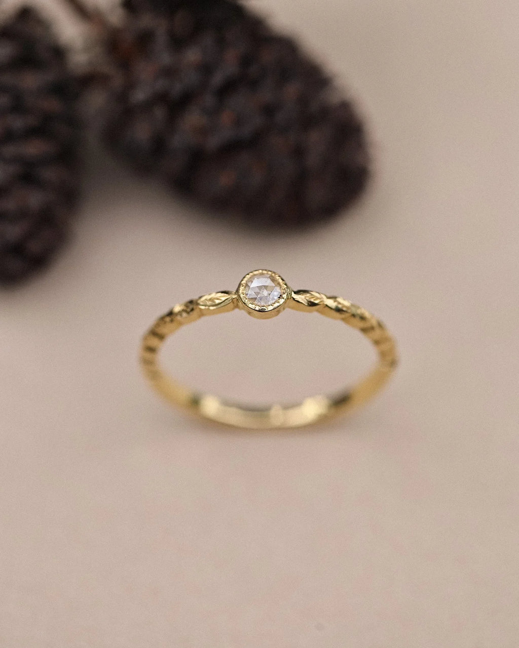 Front view of yellow gold laurel leaf ring with 3mm rose-cut diamond