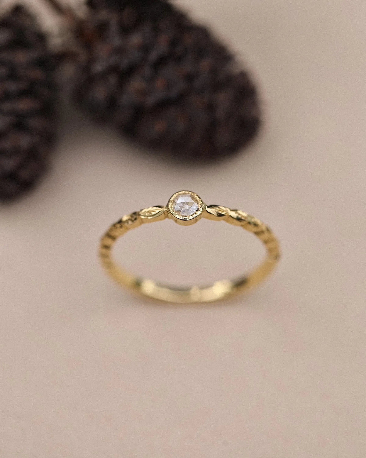 Front view of yellow gold laurel leaf ring with 3mm rose-cut diamond