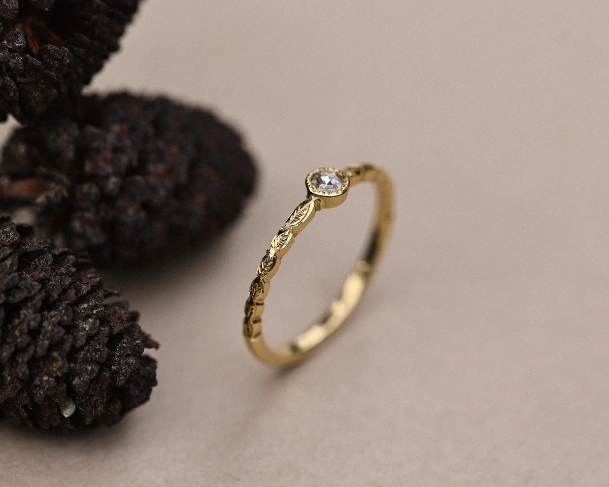 Side profile of rose-cut diamond ring with carved laurel band
