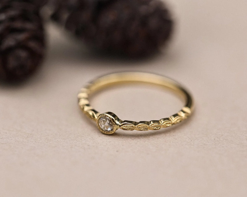 Close-up of handmade yellow gold laurel leaf ring with rose-cut diamond