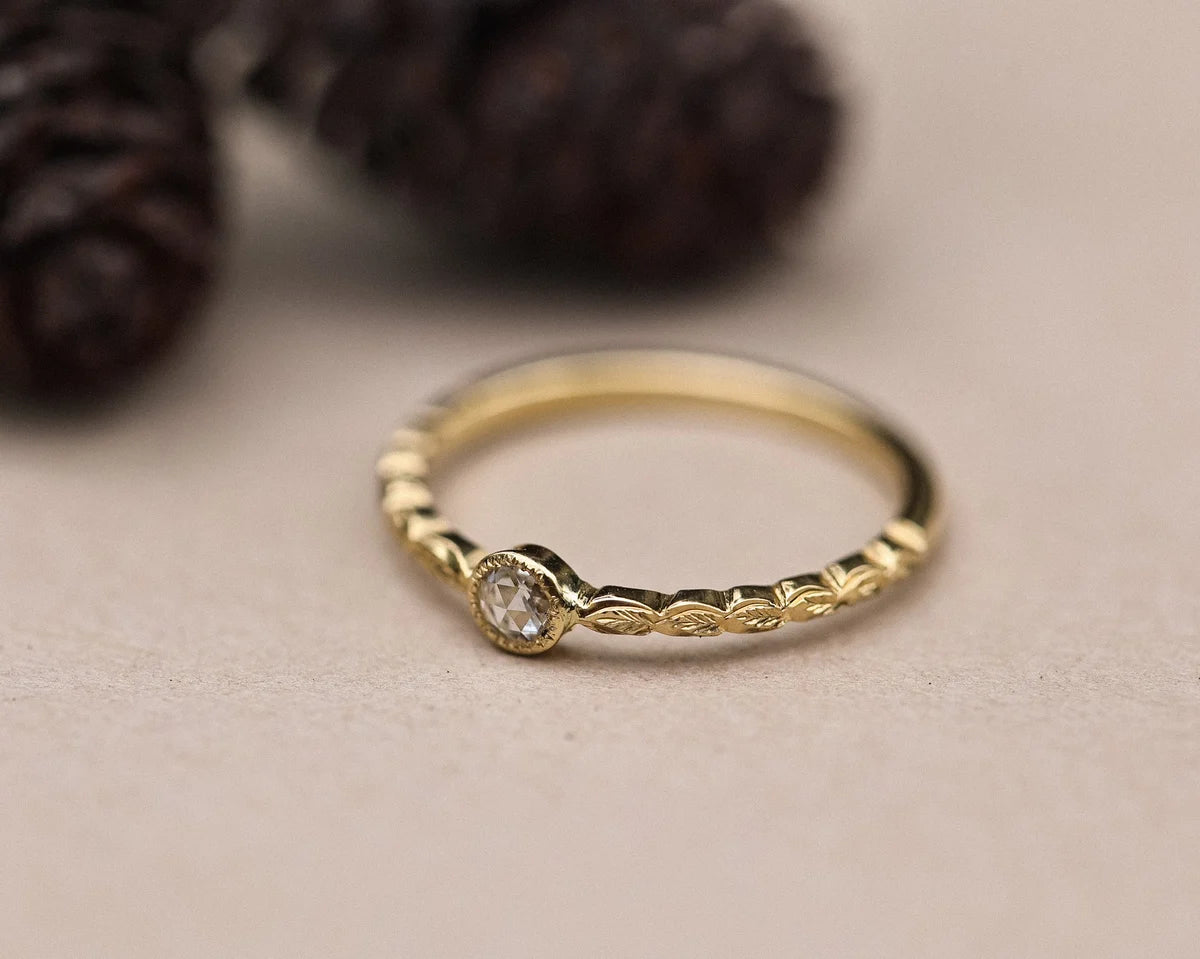 Close-up of handmade yellow gold laurel leaf ring with rose-cut diamond