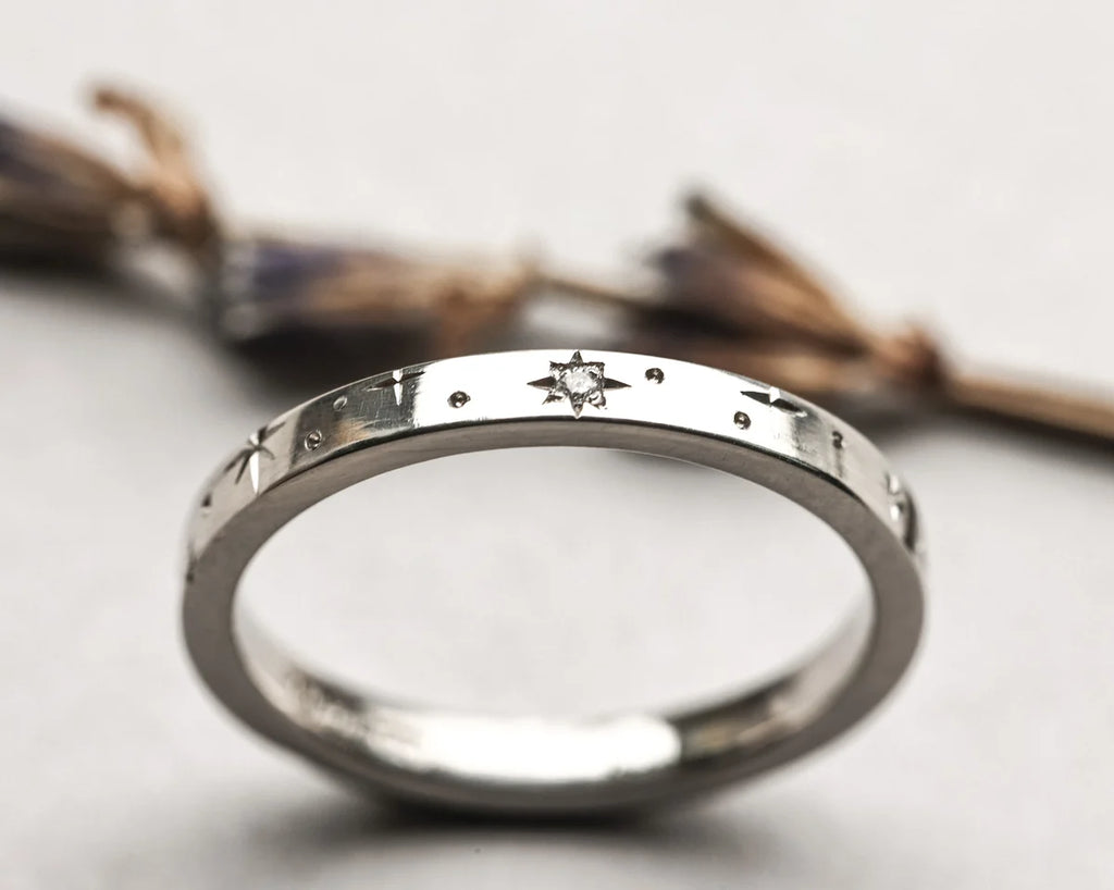 Silver ring with engraved design on a light background