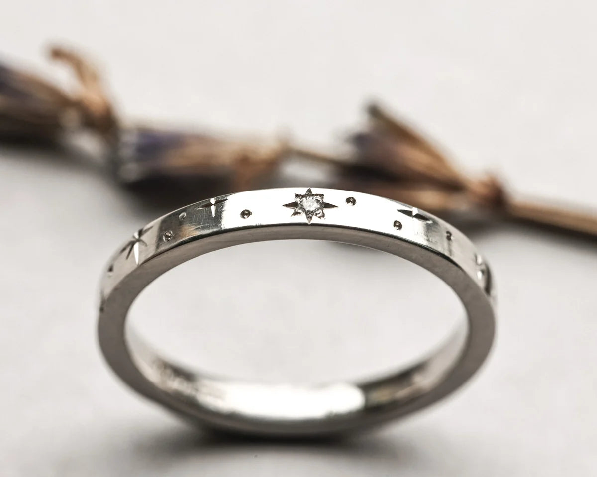 Silver ring with engraved design on a light background