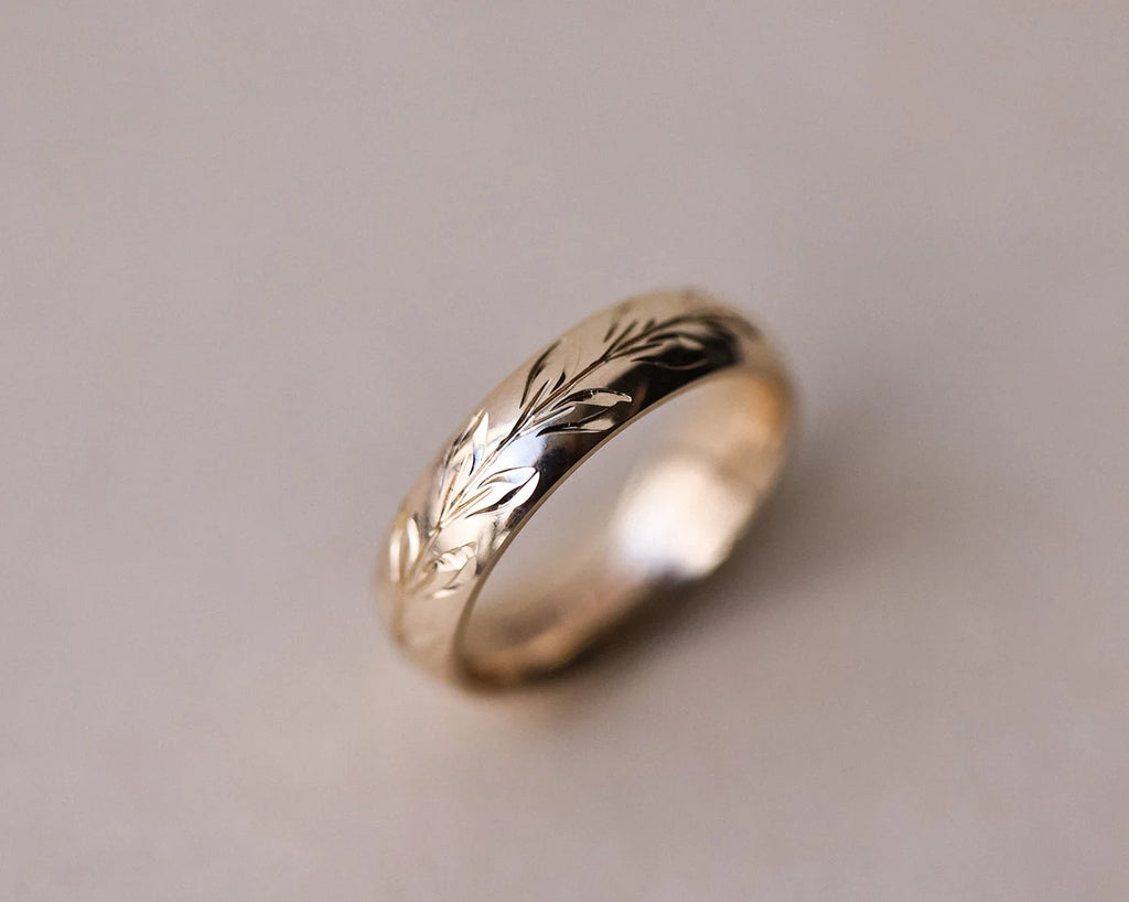 Close-up of hand engraved olive leaf detail on 9ct gold wedding ring