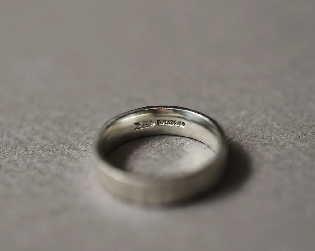 Inside view of 9ct white gold flat court wedding ring with hallmark