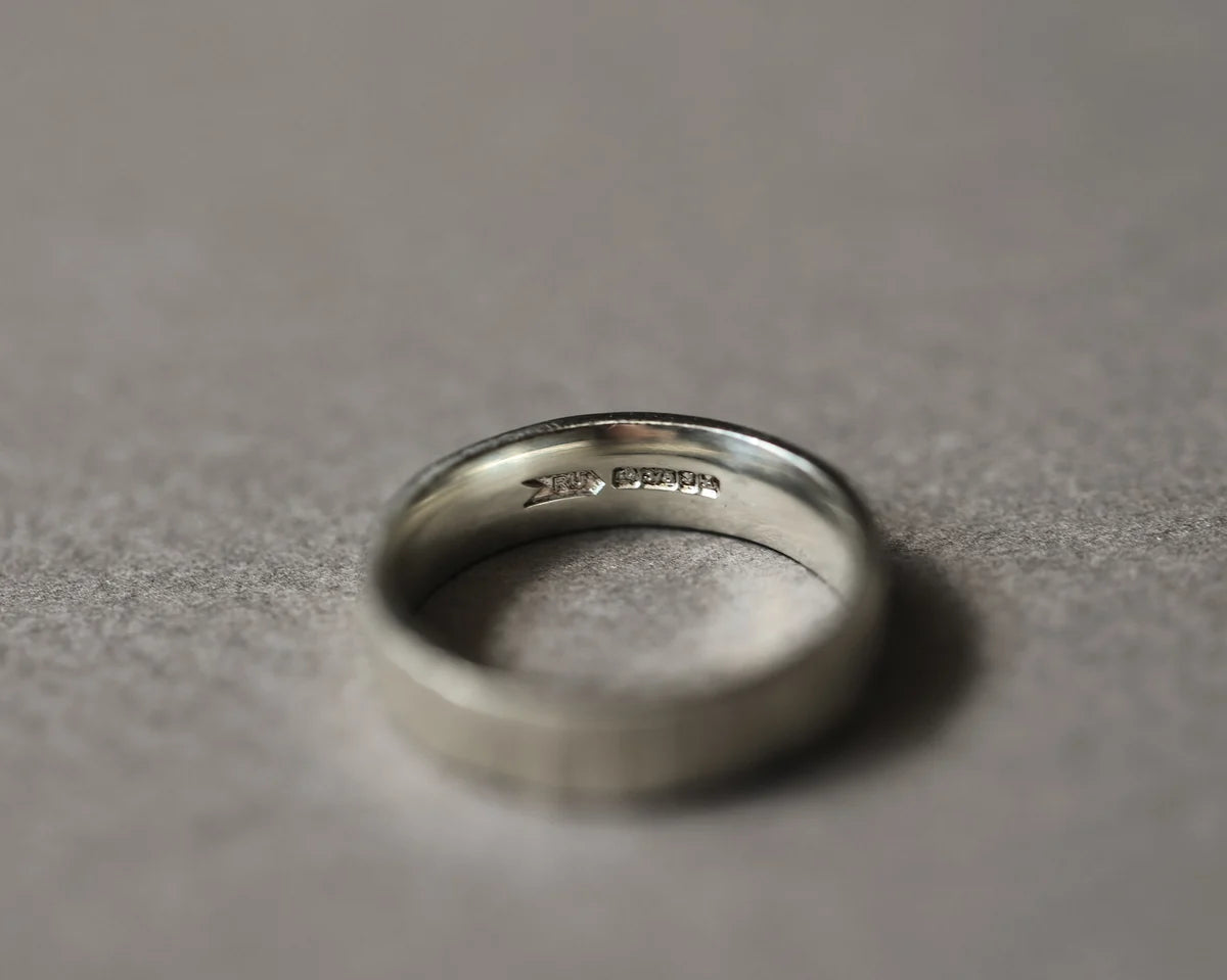 Inside view of 9ct white gold flat court wedding ring with hallmark