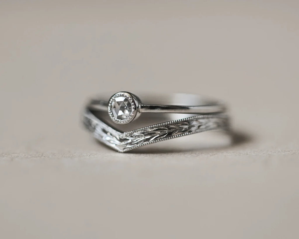 Silver ring with diamond on a light gray background