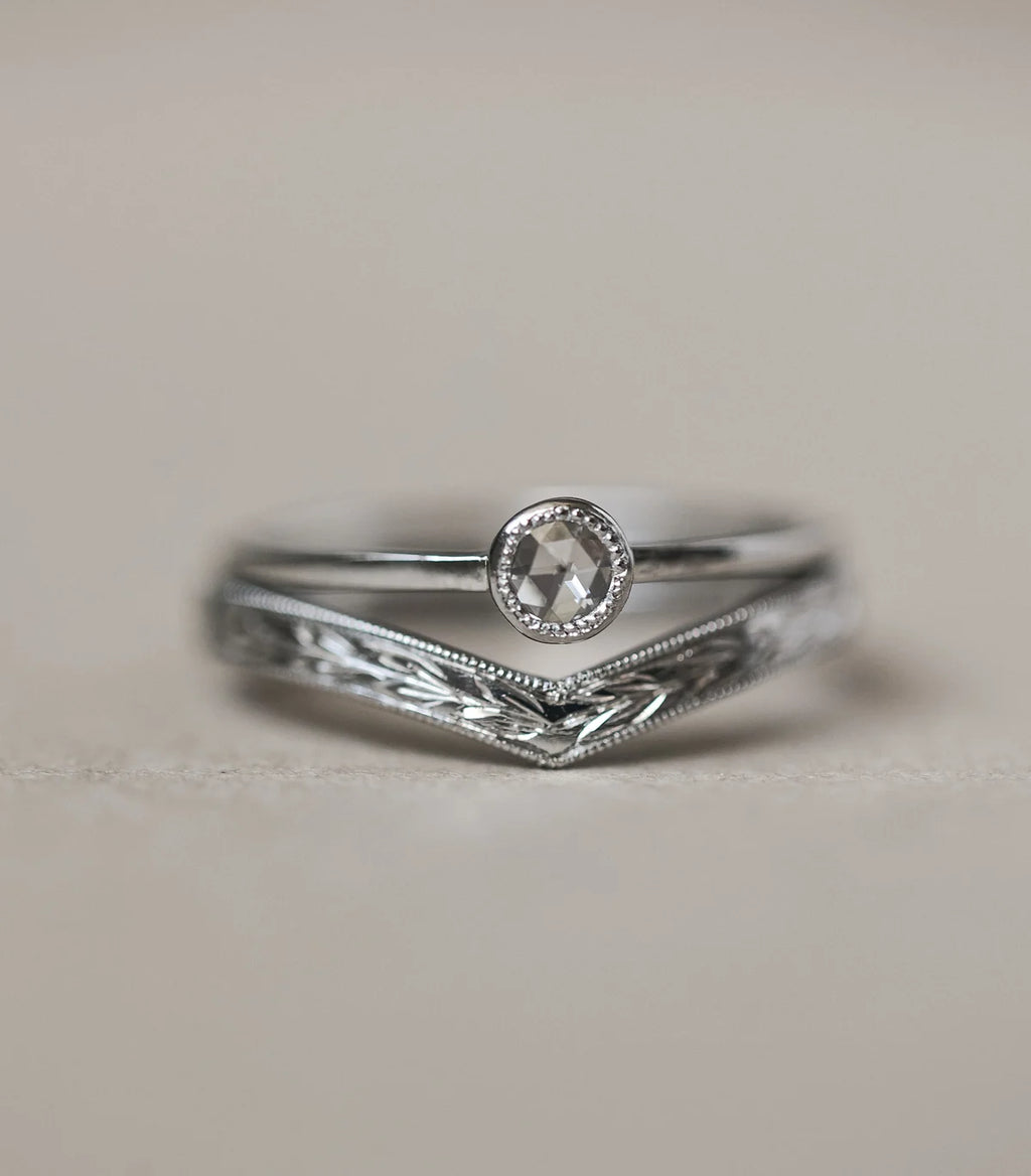 Silver ring with a diamond on a light gray background