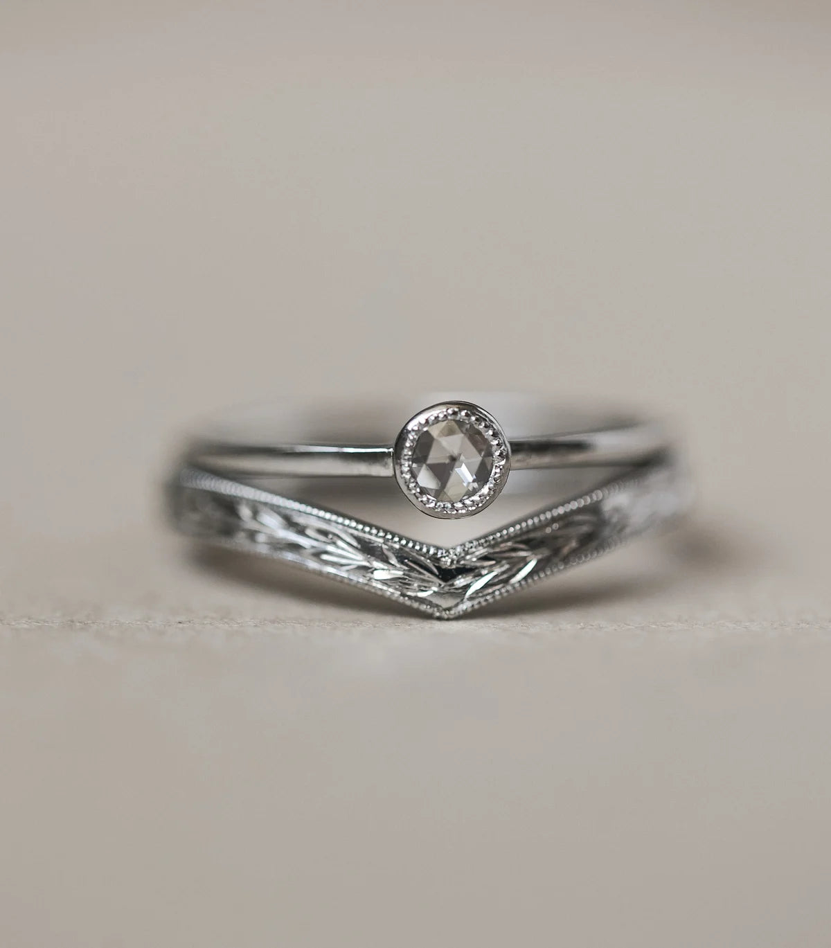 Silver ring with a diamond on a light gray background