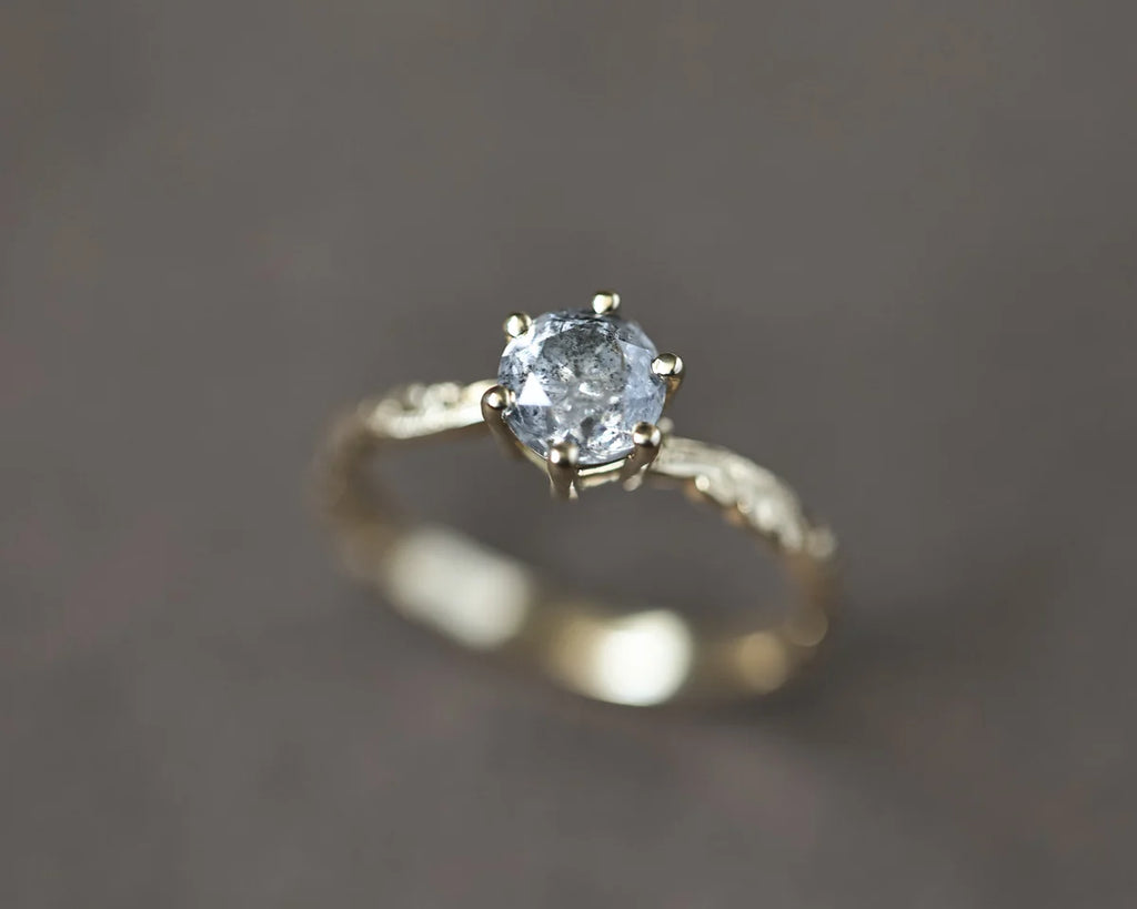 Angled close-up of 5.5mm grey salt and pepper diamond ring
