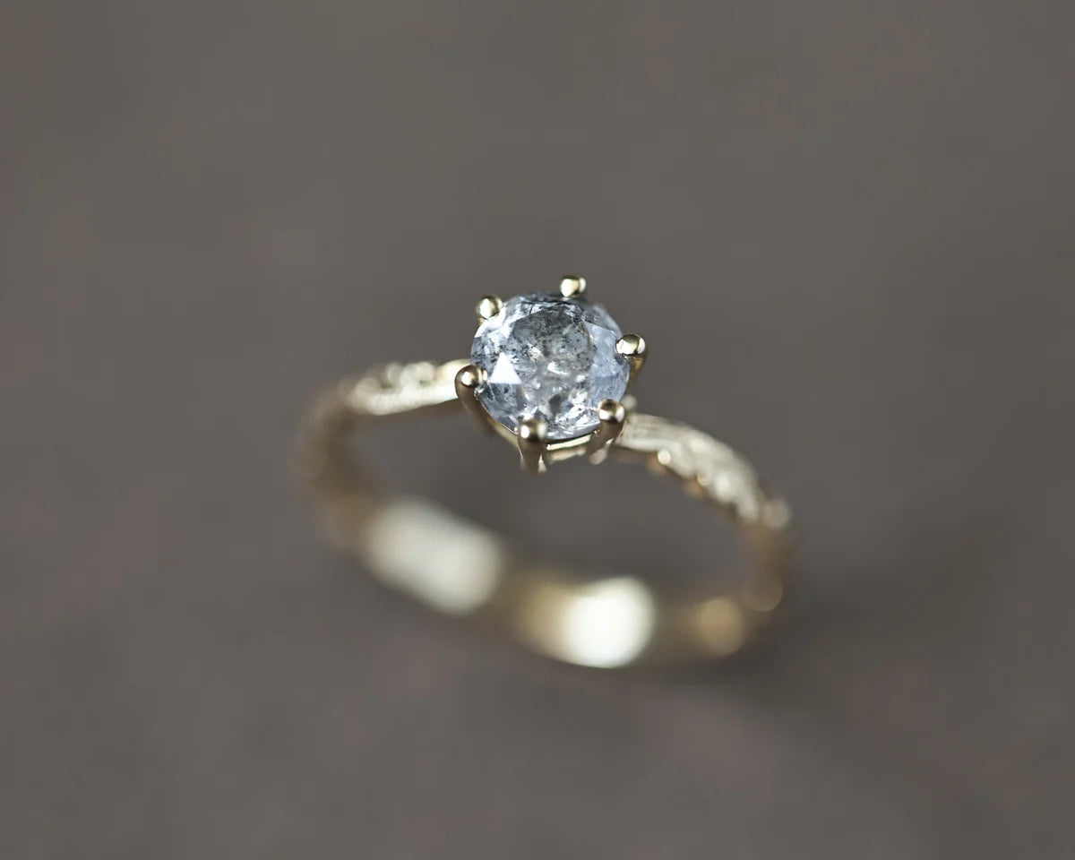 Angled close-up of 5.5mm grey salt and pepper diamond ring