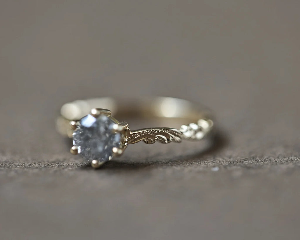 Close-up of grey salt and pepper diamond ring in yellow gold