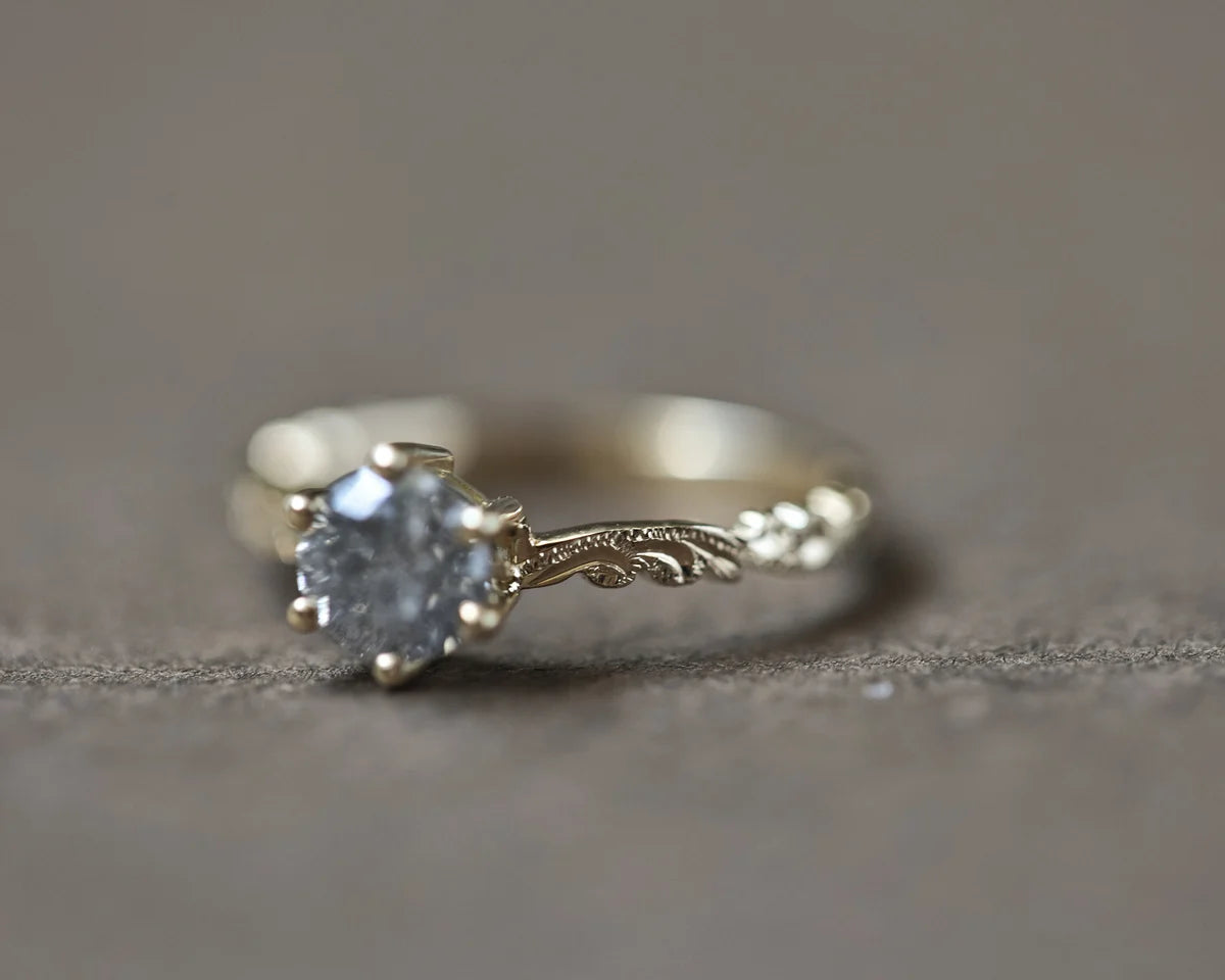 Close-up of grey salt and pepper diamond ring in yellow gold