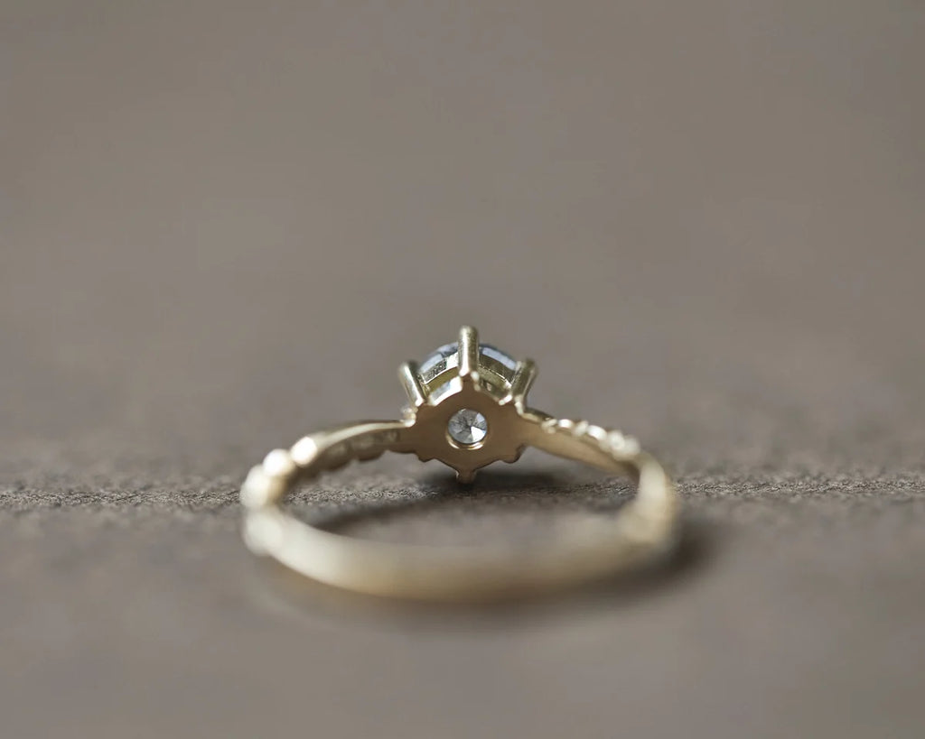 Side profile of yellow gold diamond ring with floral carved band