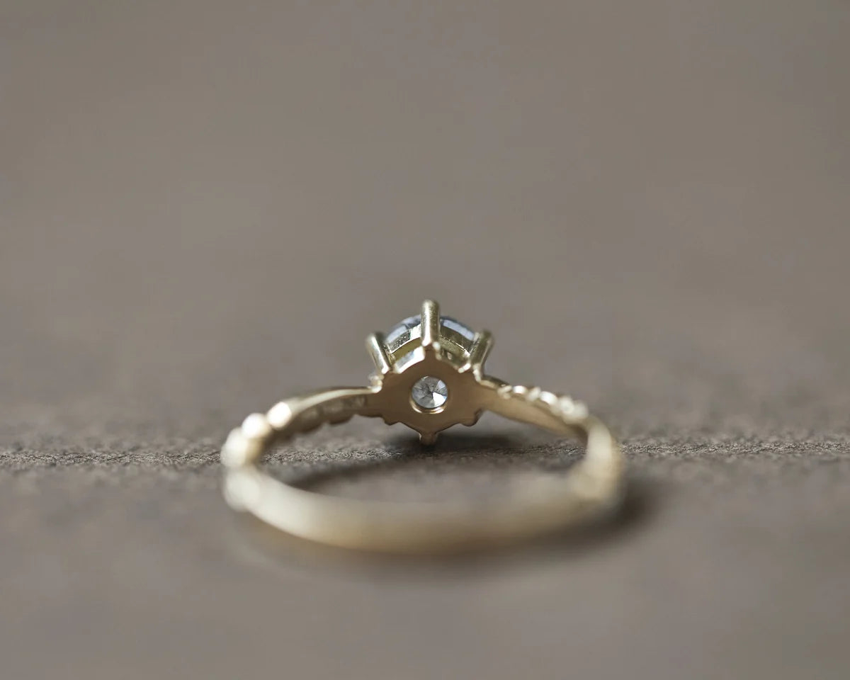Side profile of yellow gold diamond ring with floral carved band