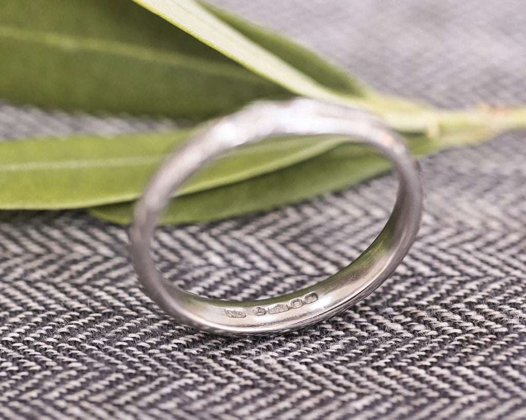 Platinum olive leaf wedding ring standing upright with botanical styling
