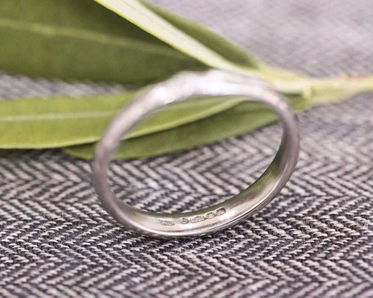 Platinum olive leaf wedding ring standing upright with botanical styling