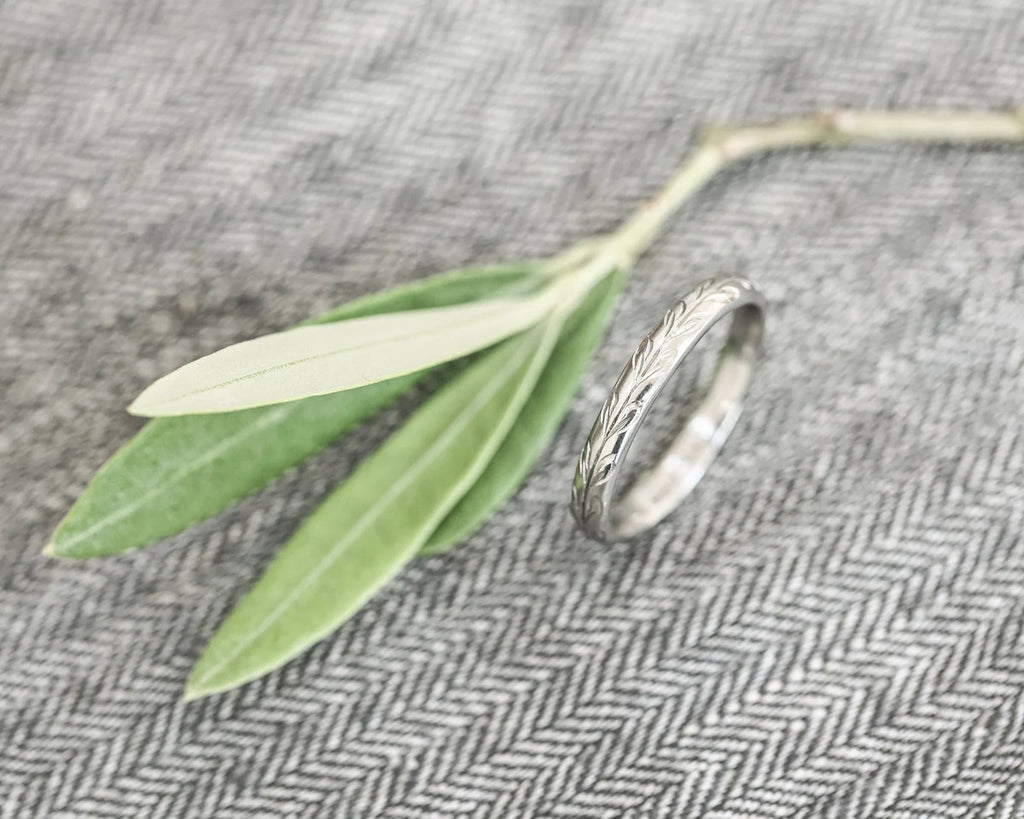 close up olive leaf engraving on platinum ring 3mm band texture