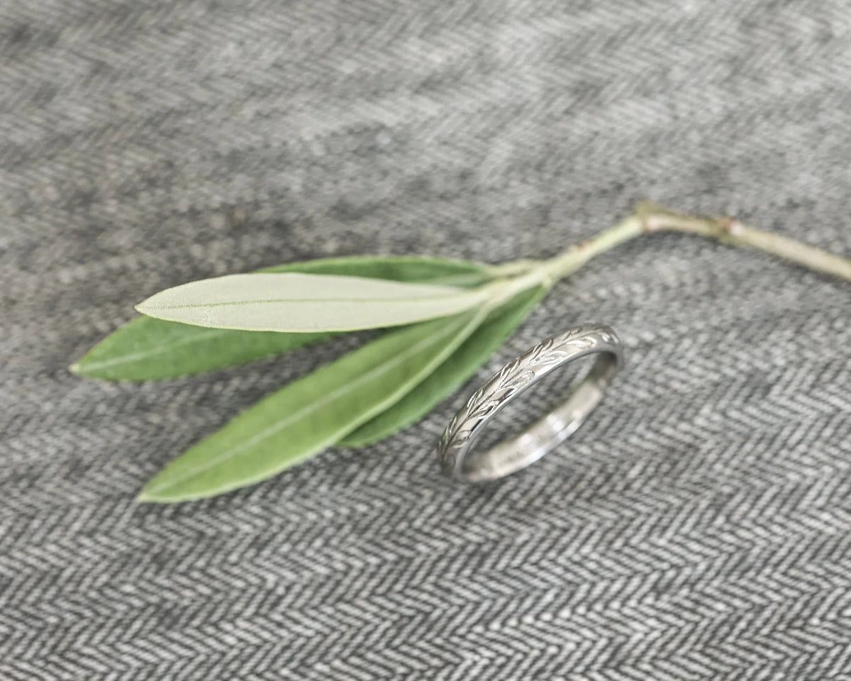 close up olive leaf engraving on platinum ring 3mm band texture