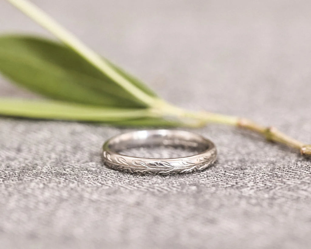 Front view of hand engraved olive leaf ring in platinum