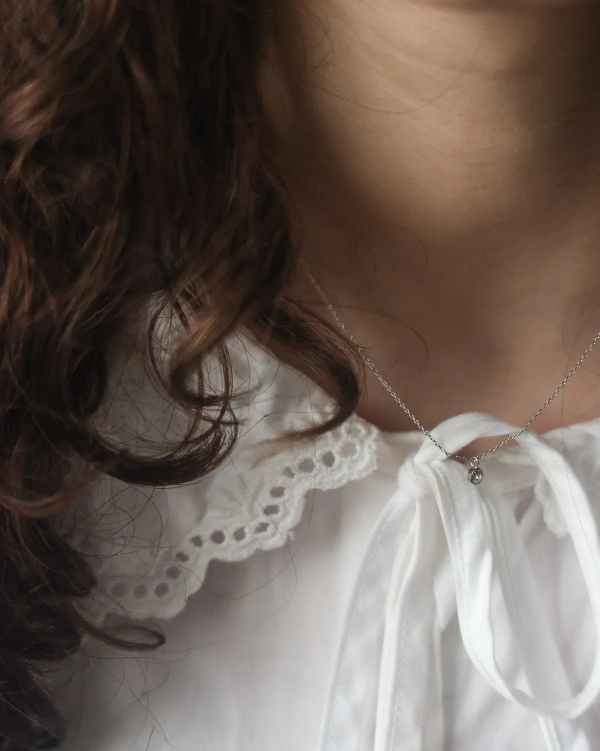 fine diamond necklace worn close to neck simple design