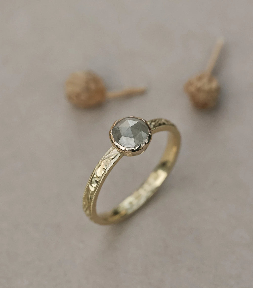 Angled close-up of handmade yellow gold diamond ring