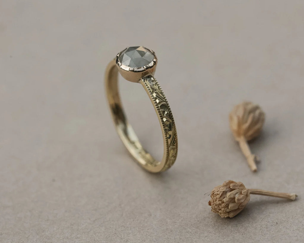 Side view of pale grey rose-cut diamond ring with floral engraved band